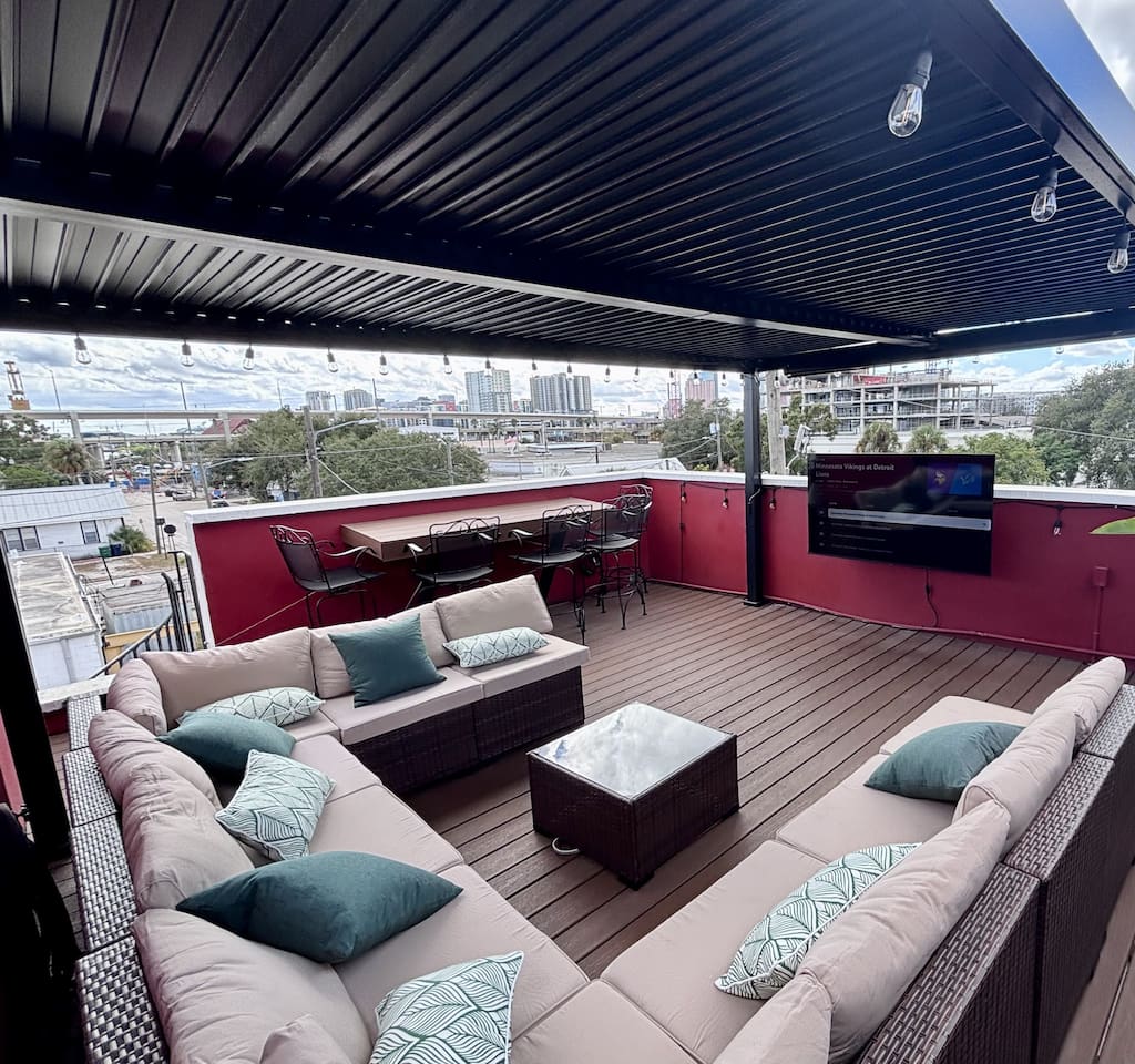 Shaded rooftop terrace with sectional and bar